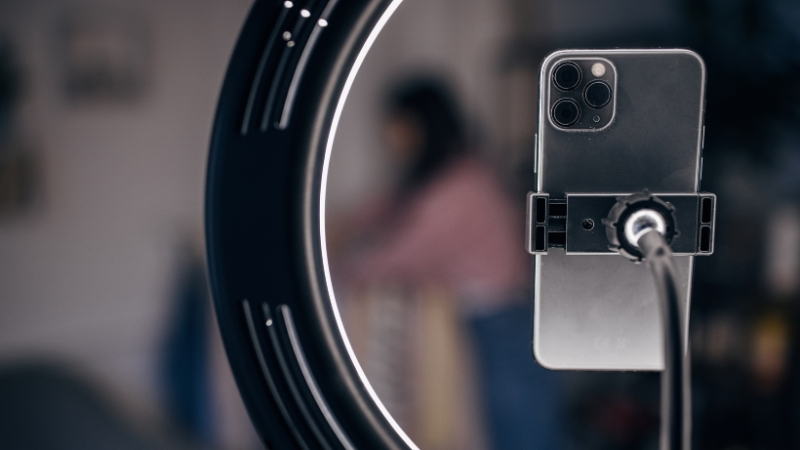 A smartphone set up with a ring light, ready to record content for social media by a creator or micro-influencer