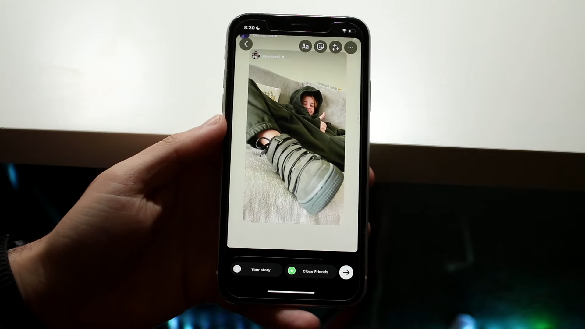 Person holds a phone with a Story on Instagram ready to repost