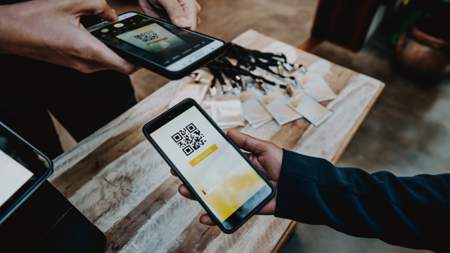A person scans a QR code on a smartphone at a large-scale event registration or activation area