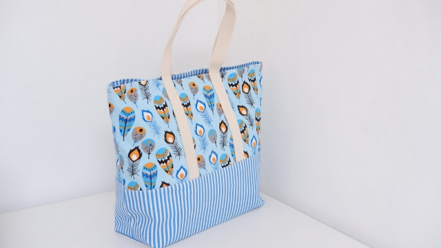 A blue patterned tote bag with sturdy fabric handles placed against a plain white background