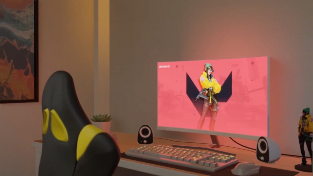 A clean desk setup features a Valorant-themed monitor display with matching accessories