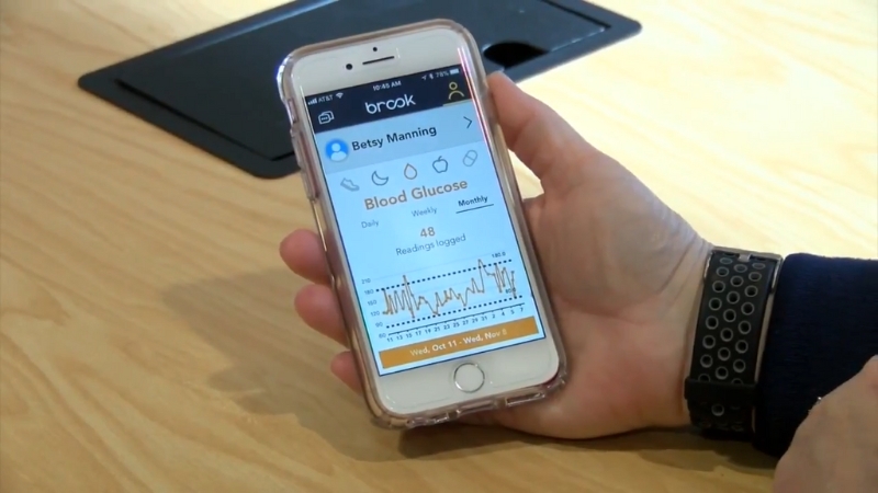 A patient checks blood glucose levels on a smartphone health tracking app