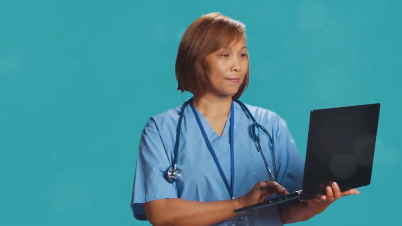 A healthcare professional uses a laptop to support clear and inclusive communication with patients