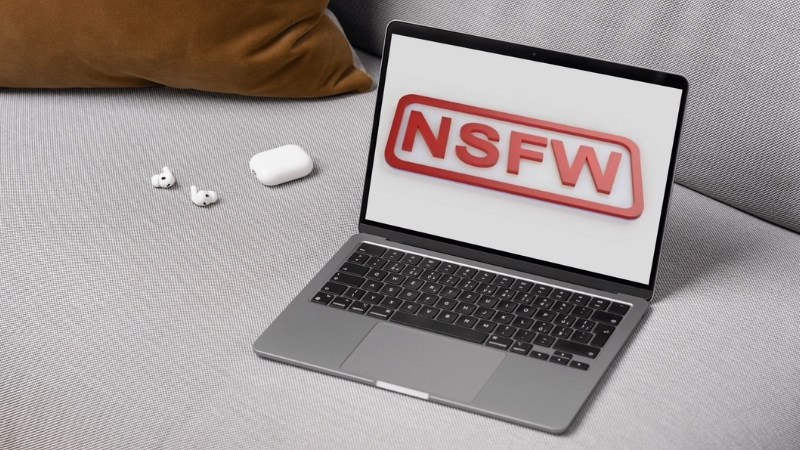 Laptop displaying an NSFW warning on screen to illustrate ad compliance risks for adult websites