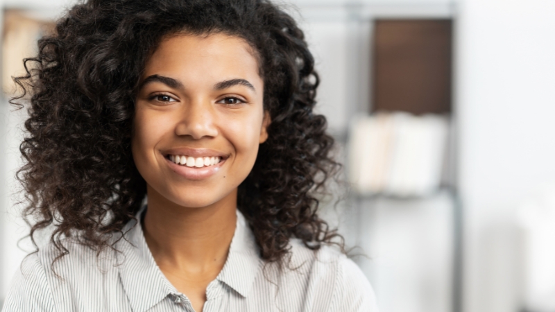 Portrait of a smiling woman with natural skin texture after Photoshop retouching for headshots